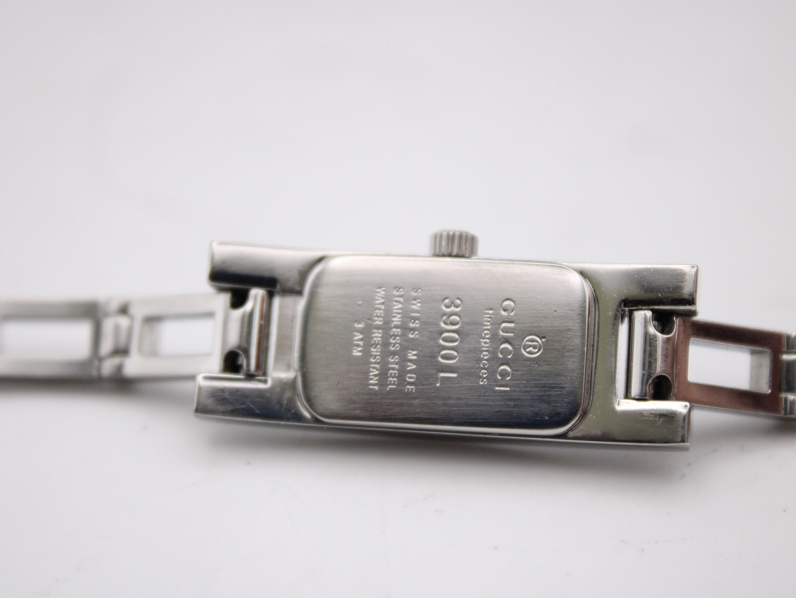 Close-up of the watch case back, showing "GUCCI", "SWISS MADE", "STAINLESS STEEL", "WATER RESISTANT 3 ATM", and "3900L".