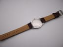 Back view of the Tissot PR 50 watch, showing the case back and the full length of the brown leather strap, with "Genuine Leather" and "18" embossed.