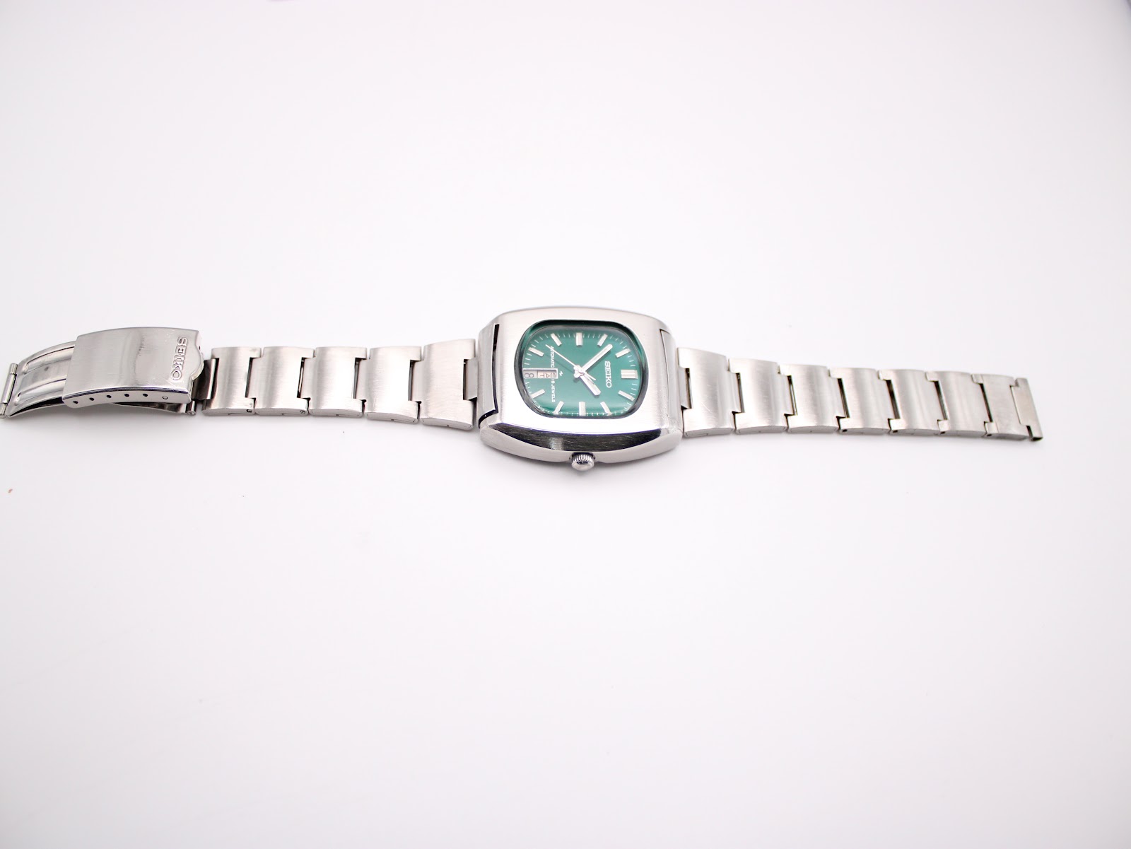 Full length view of the Seiko 7006-5070 watch and its integrated stainless steel bracelet, laid flat.