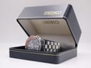 Side view of the Seiko watch nestled inside its original dark blue Seiko box with gold lettering.