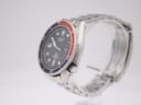 Right profile view of the Seiko diver watch on a clear display stand, showing the crown and knurled bezel edge.