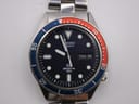 Overhead view of the Seiko 7546-6040 watch dial, highlighting the day-date complication and lumed indices.