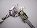 Top-down view of the watch being measured by a digital caliper, displaying a case diameter of 38.77 mm.