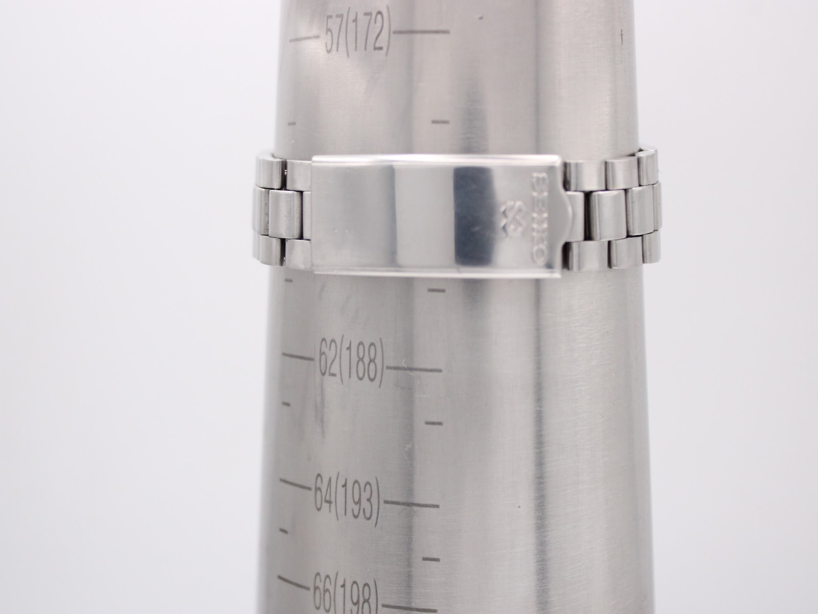 Close-up of the watch's stainless steel bracelet with a signed Seiko clasp on a wrist sizing cone, showing a wrist size of approximately 186mm.
