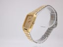 Side profile view of the gold tone Seiko 6531-5170 watch on a clear display stand, showing the crown.