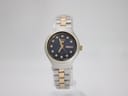 Front view of Seiko 5 automatic watch with black dial, day-date window, and stone hour markers on a two-tone bracelet.