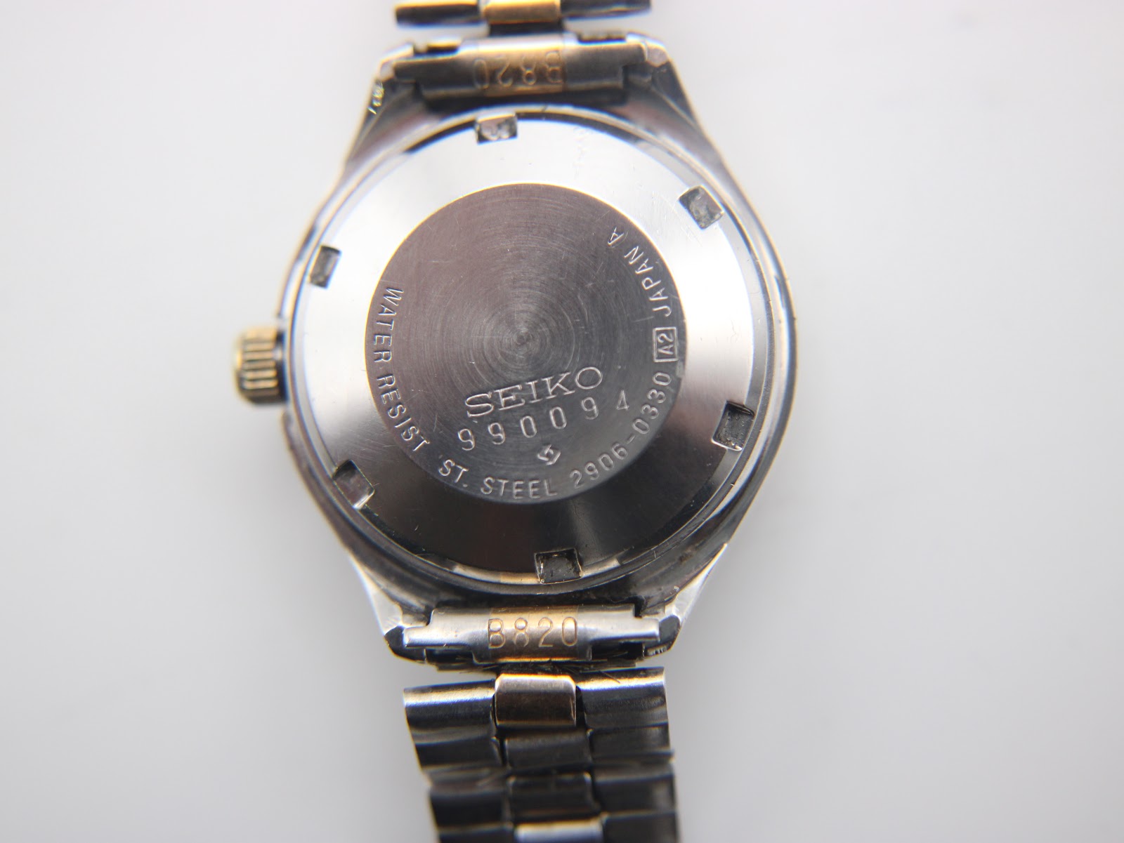 Close-up of the polished stainless steel case back, showing 'SEIKO WATER RESIST ST. STEEL 2906-0330' engraving and serial number.