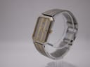 Angled side profile of the Seiko 2A32-5060 watch on a display stand, showcasing its slim rectangular case, gold-toned bezel, and integrated bracelet.