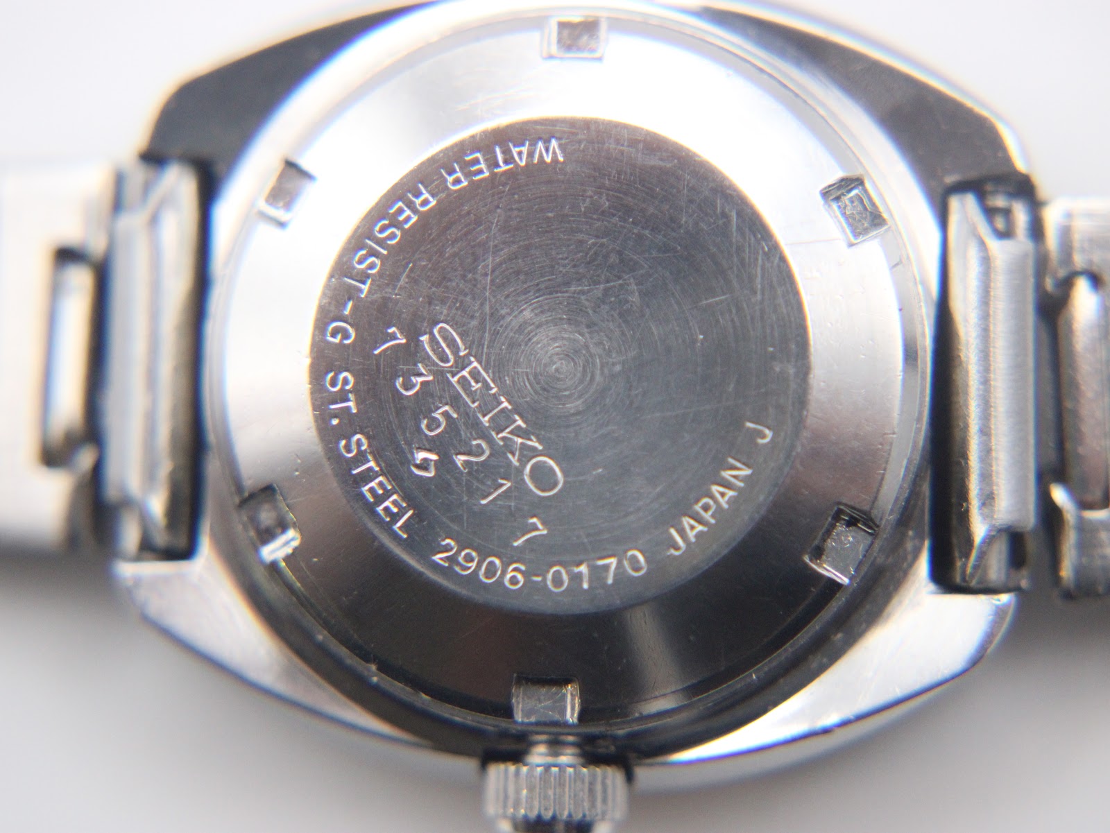 Detail of integrated stainless steel bracelet links showing brushed top surfaces and polished edges with light age-appropriate surface wear