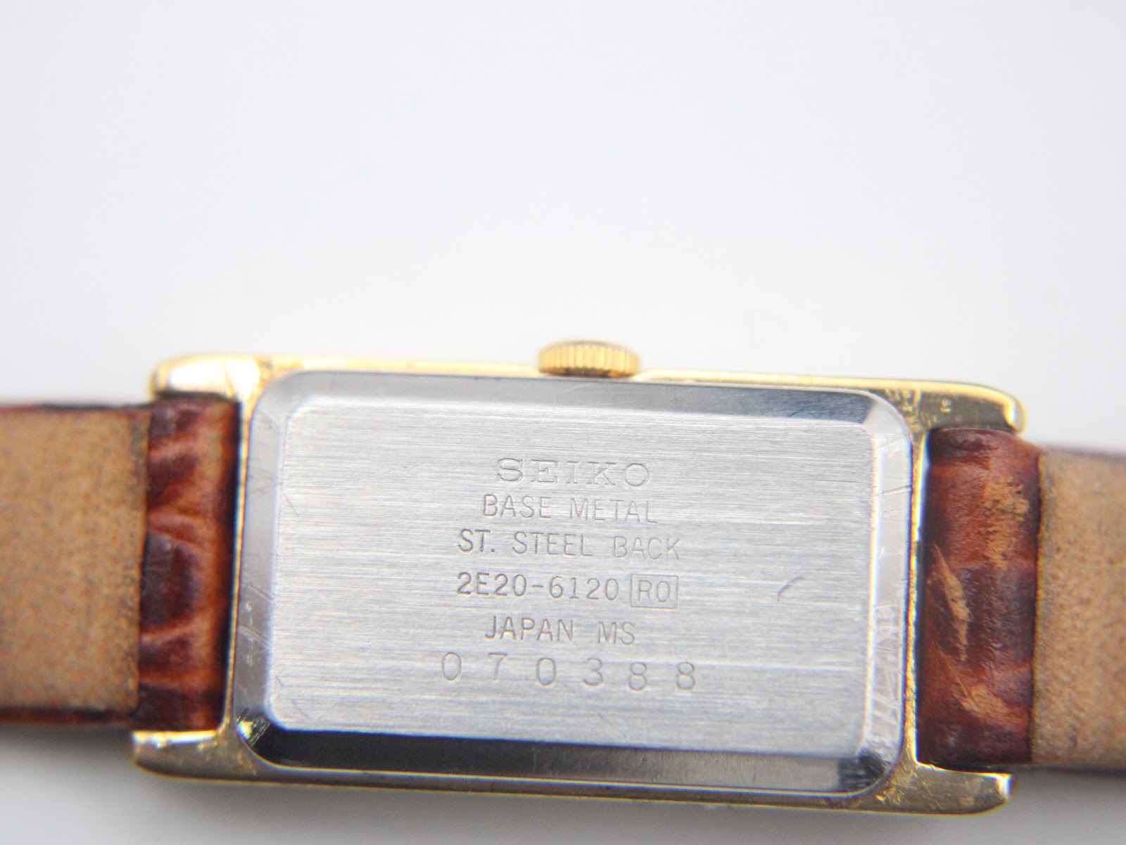 Close-up of the brushed stainless steel case back of the Seiko 2E20-6120, showing model number and serial 070388.