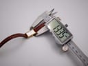 Digital caliper measuring the case width of the Seiko watch, showing a precise measurement of 13.35mm on the display.