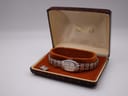 The vintage Seiko watch displayed in its original brown faux-crocodile presentation box with orange velvet interior, the clasp visible.