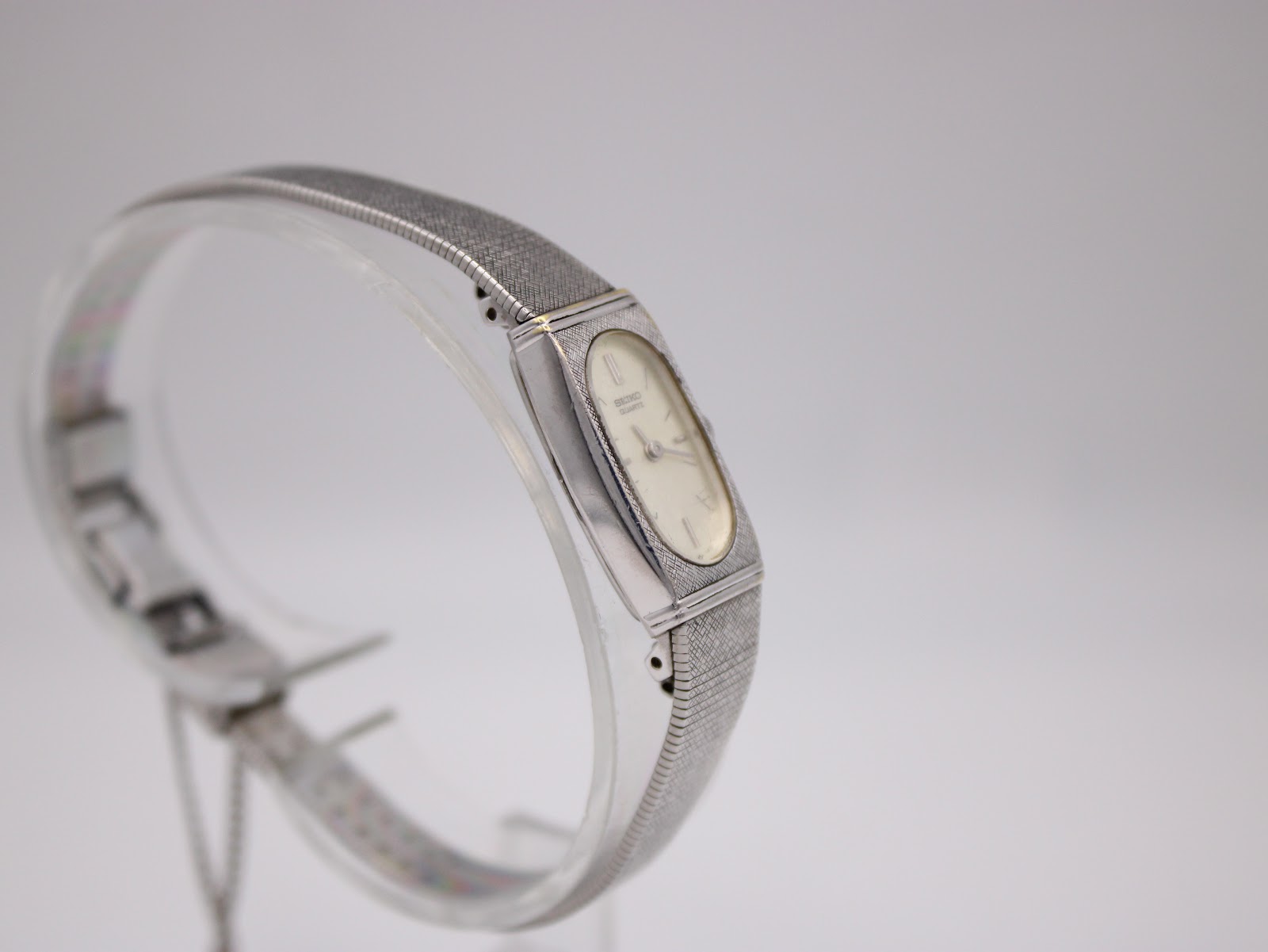 Another angled view of the Seiko watch on a display stand, highlighting the integrated bracelet design.