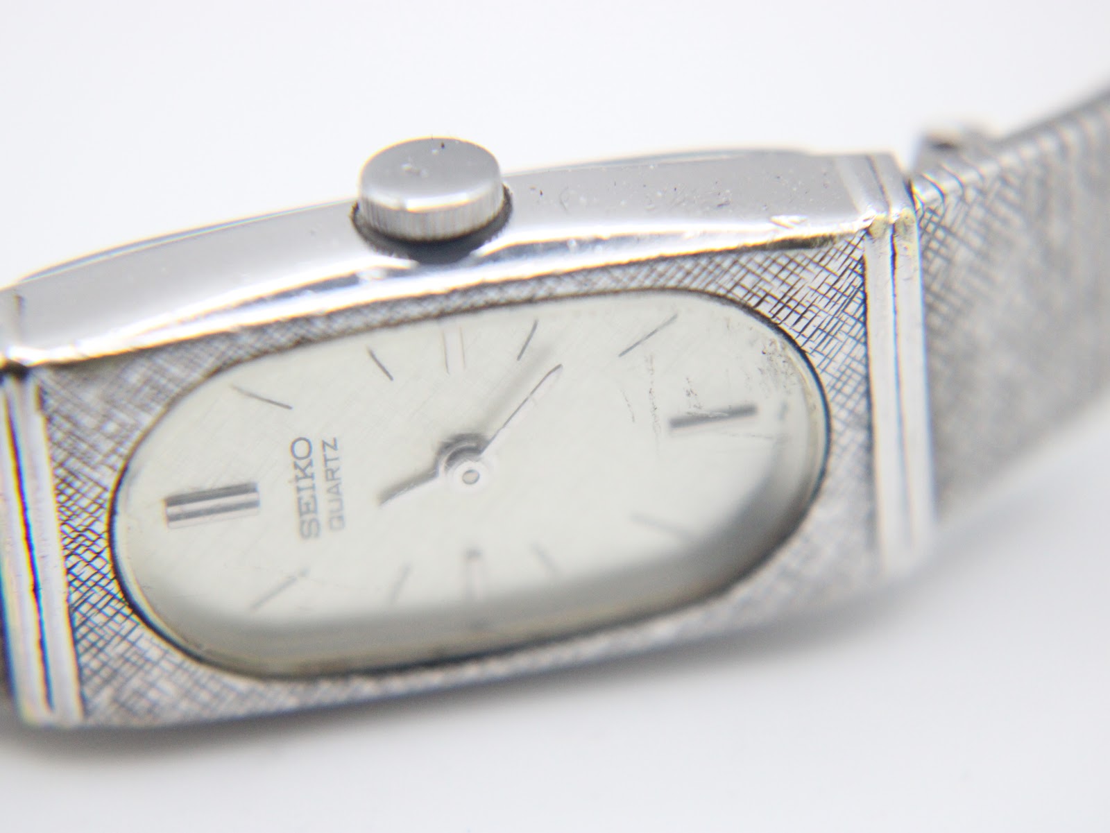 Detailed close-up of the watch dial, showing "SEIKO QUARTZ" text, baton indices, and minor crystal wear.