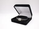 The Seiko watch nestled inside an open black velvet watch box.