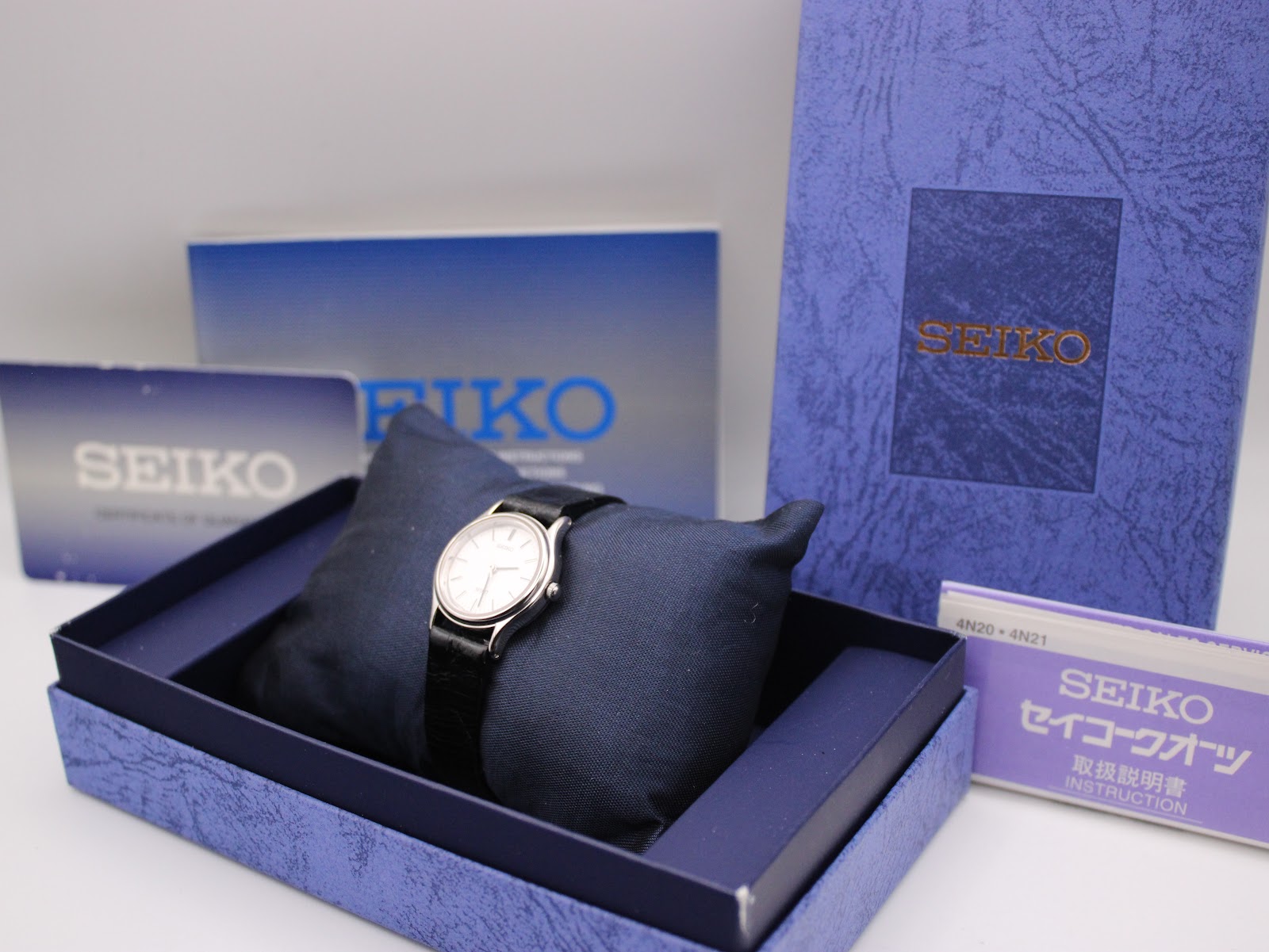 Close-up of the brushed stainless steel case back of the Seiko watch, showing "SEIKO WATER RESISTANT 5 BAR 4N21-0450 A0 ANTIMAGNETIC 60G" and serial number.
