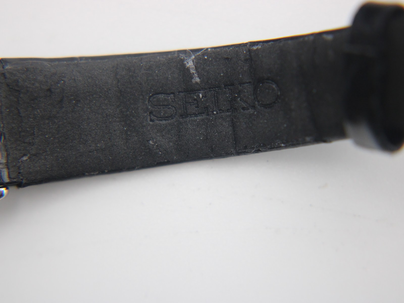 Close-up of the inside of the black leather strap, with "SEIKO" embossed clearly.
