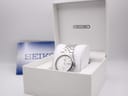 Side profile of Seiko SQ 100 showing slim tonneau-style case, fluted crown at 3 o'clock, and integrated bracelet lugs