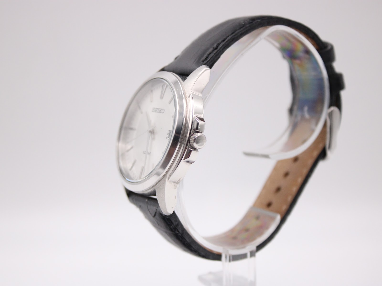 Close-up of polished Seiko-signed pin buckle on black crocodile-grain leather strap
