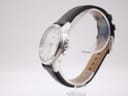 Close-up of polished Seiko-signed pin buckle on black crocodile-grain leather strap