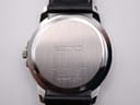 Detail of black embossed crocodile-grain leather strap showing outer surface texture and tan inner lining