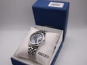 Seiko 7N43-0AM0 in its original navy blue hinged presentation box on a white cushion with the box lid open