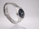 Another side profile view of the Seiko 7N43-0AM0 on a display stand, highlighting the case curve and integrated bracelet