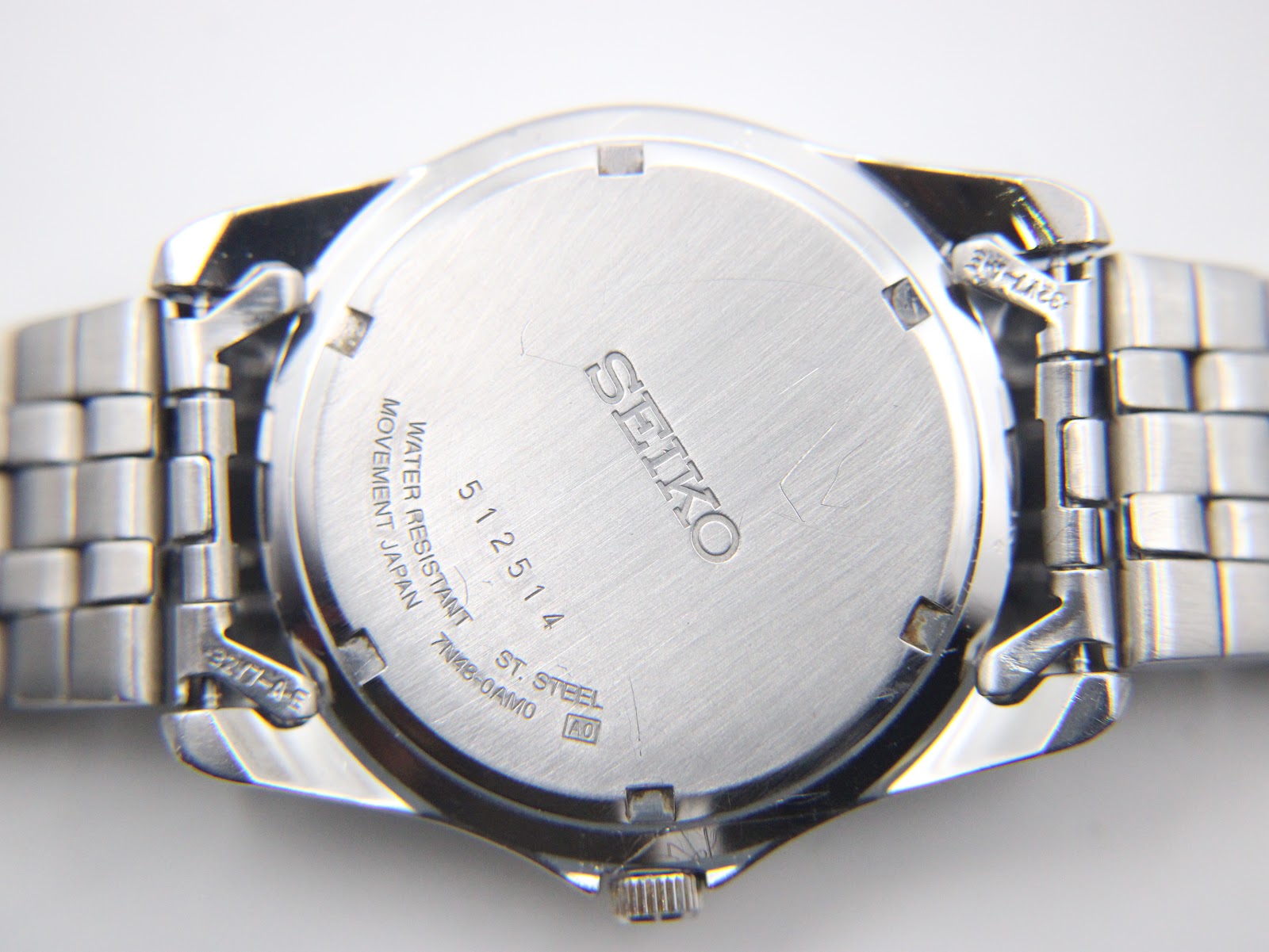 Close-up of the brushed stainless steel case back with Seiko logo, serial number '512514', and 'water resistant' engraving