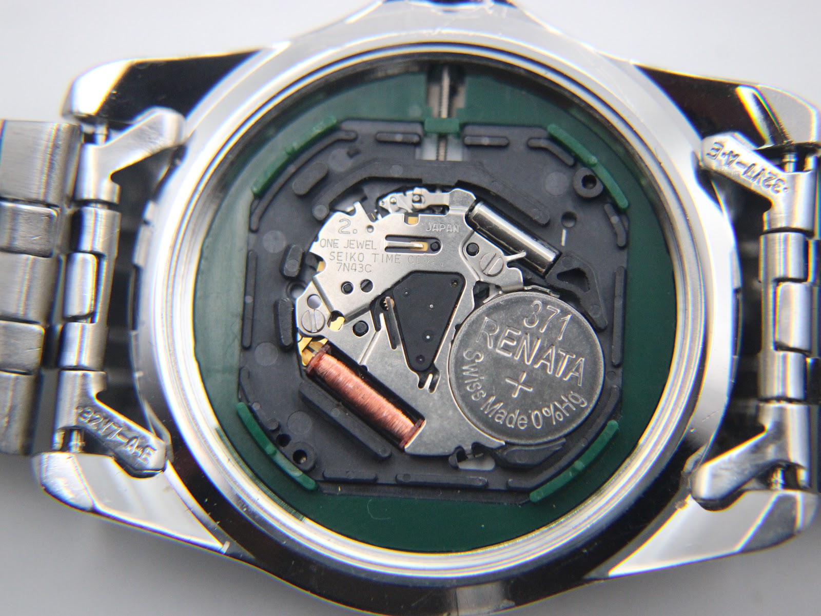 Close-up of the Seiko 7N43C quartz movement inside the case, showing the Renata 371 battery and one jewel