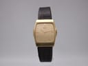 Front view of the Seiko 4730-5030 quartz watch with a gold rectangular case and gold dial on a stand.