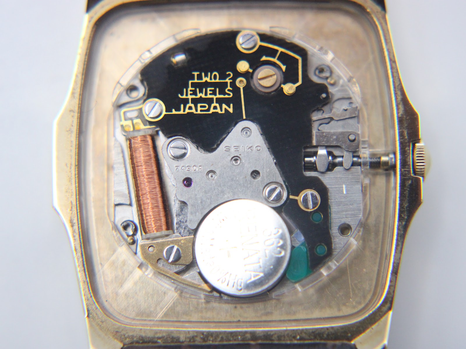 Close-up of the Seiko 7430A quartz movement inside the open case, showing battery and internal components.
