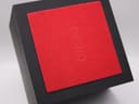 Close-up of the top of the black original Seiko watch box, showing an embossed Seiko logo on the red interior cushion.