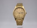 Front view of the gold-tone Seiko 7N43-9011 watch with a sunburst gold dial and day-date display.