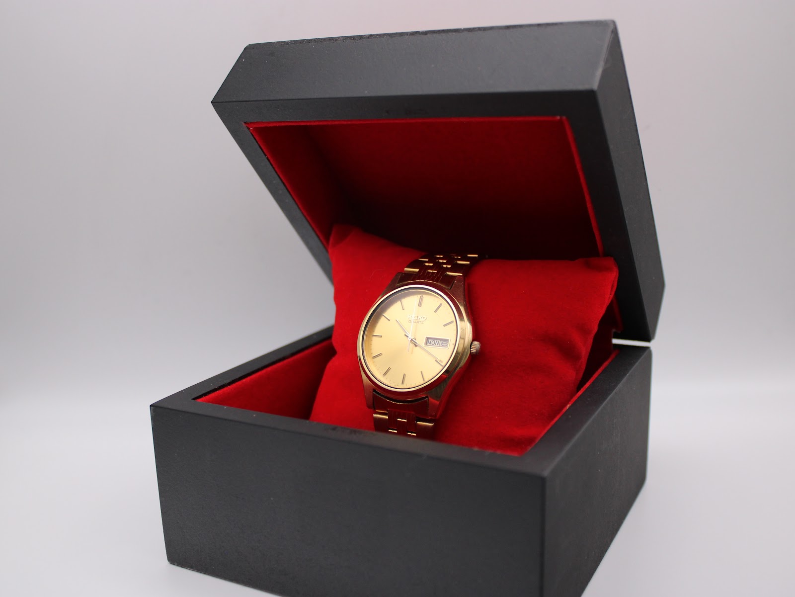 Seiko gold-tone watch presented in a black and red display box.