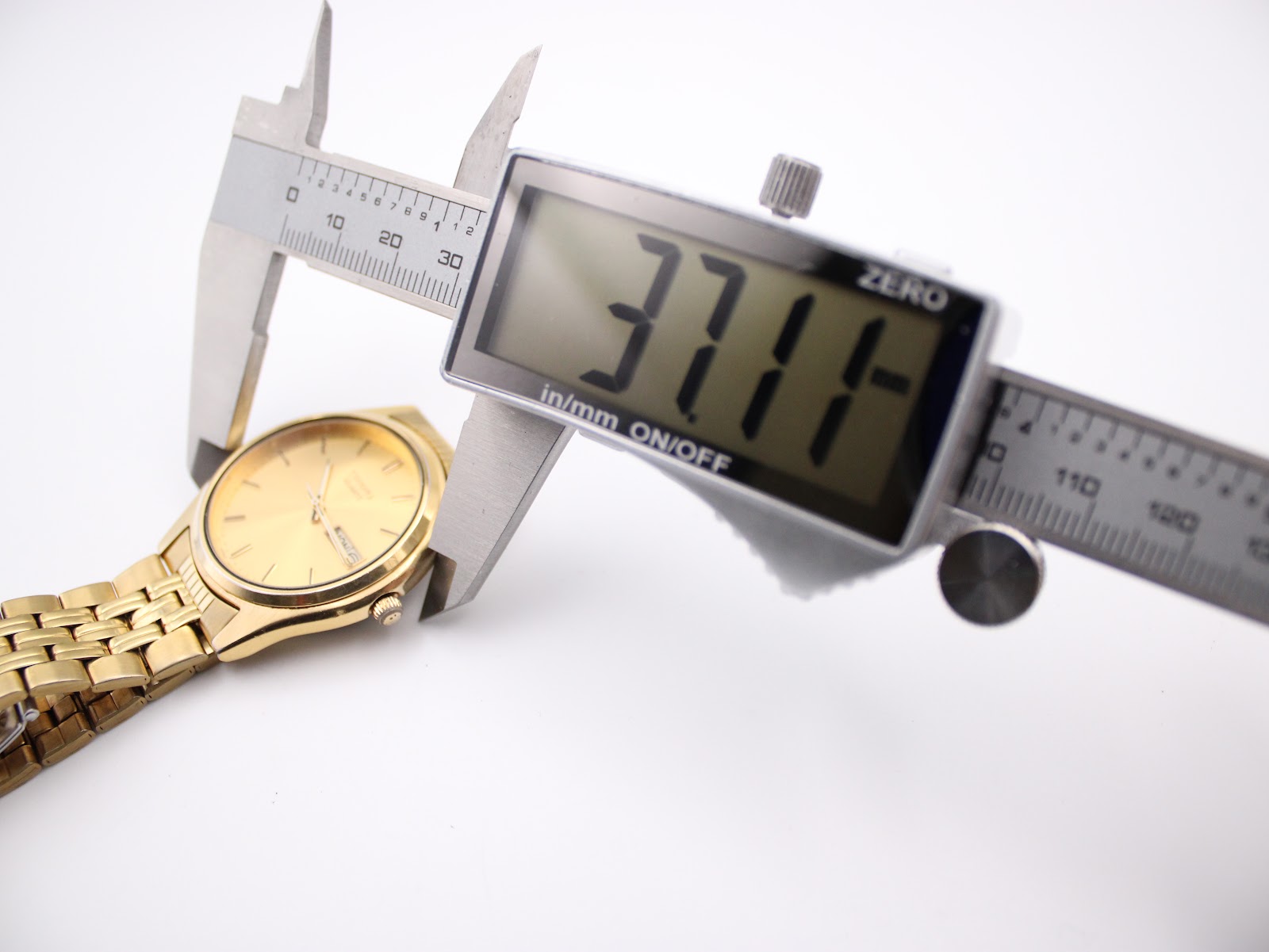 Digital caliper measuring the case diameter of the Seiko watch, displaying 37.1 mm.