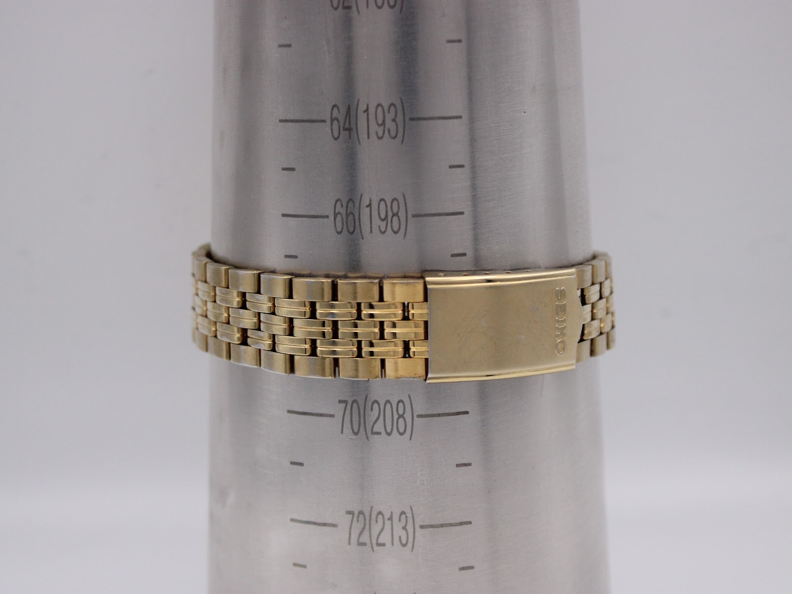 Close-up of the Seiko signed deployant clasp on a wrist sizing gauge, showing a wrist circumference of approximately 20.8cm.