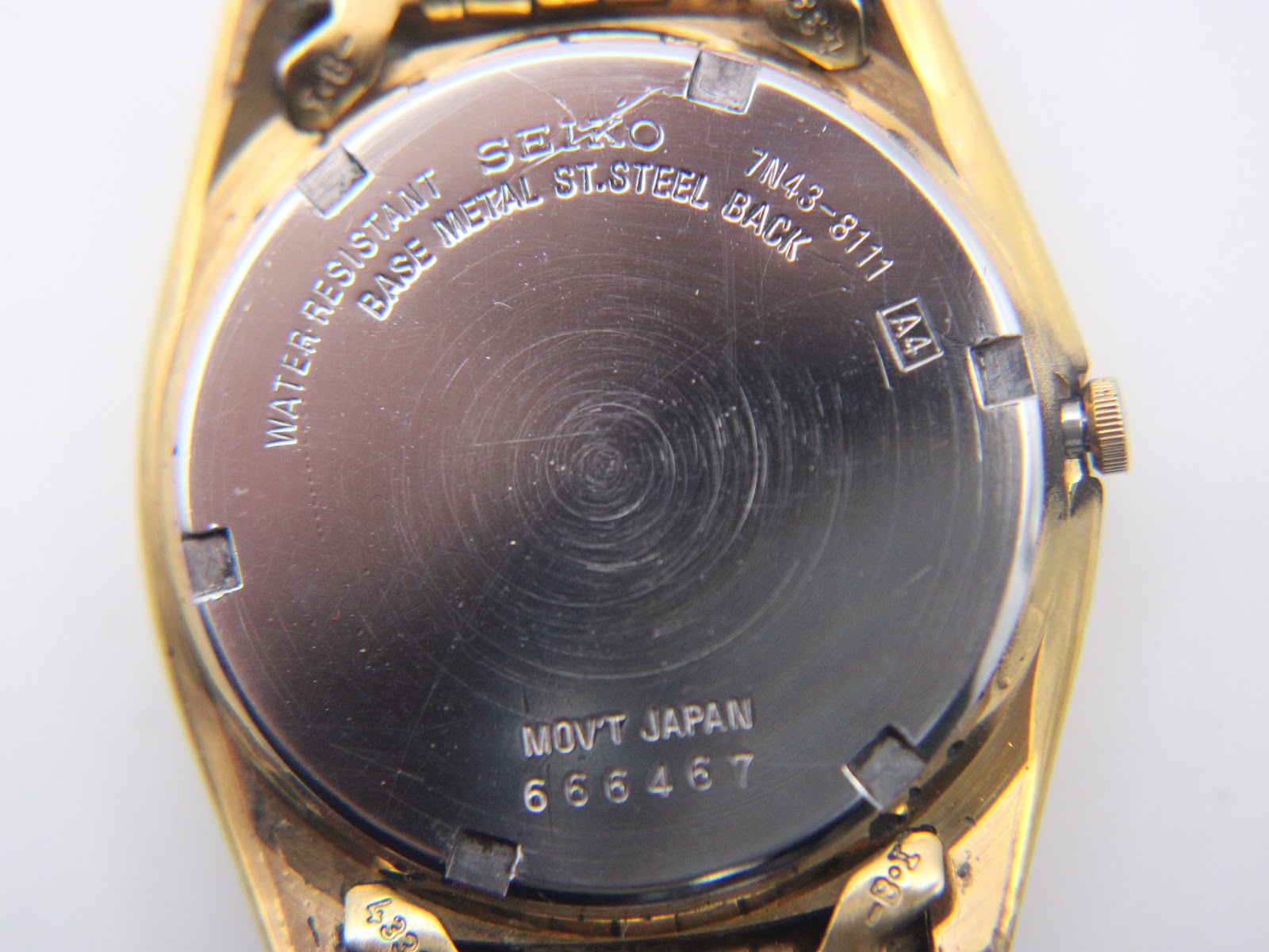 Close-up of the stainless steel case back, showing "SEIKO WATER RESISTANT BASE METAL ST.STEEL BACK 7N43-8111 MOV'T JAPAN 666467".