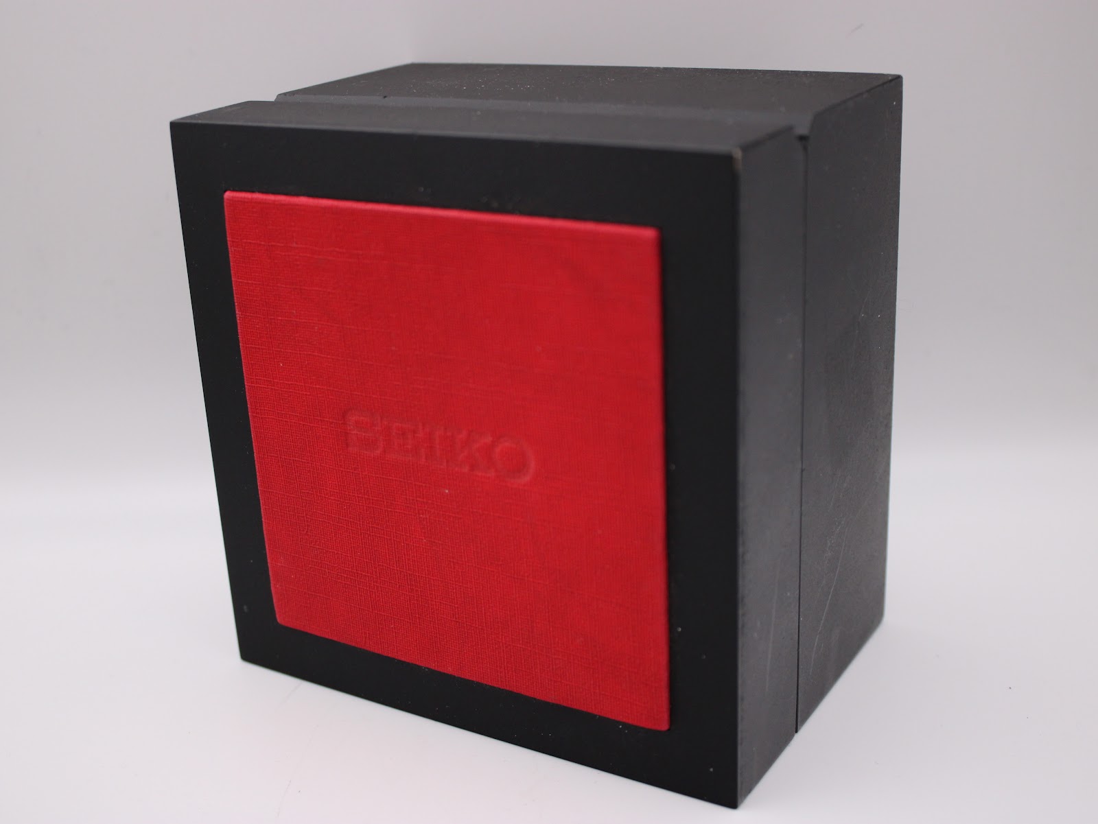 Exterior view of a black display box with a red top, embossed with "SEIKO".