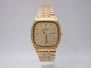 Front view of the vintage gold-tone Seiko quartz watch with a rectangular case and matching gold dial, showing day-date window.