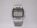 Front view of the Seiko A229-5060 digital watch, showing time 8:34:07 and day/date, with a silver stainless steel case and bracelet.
