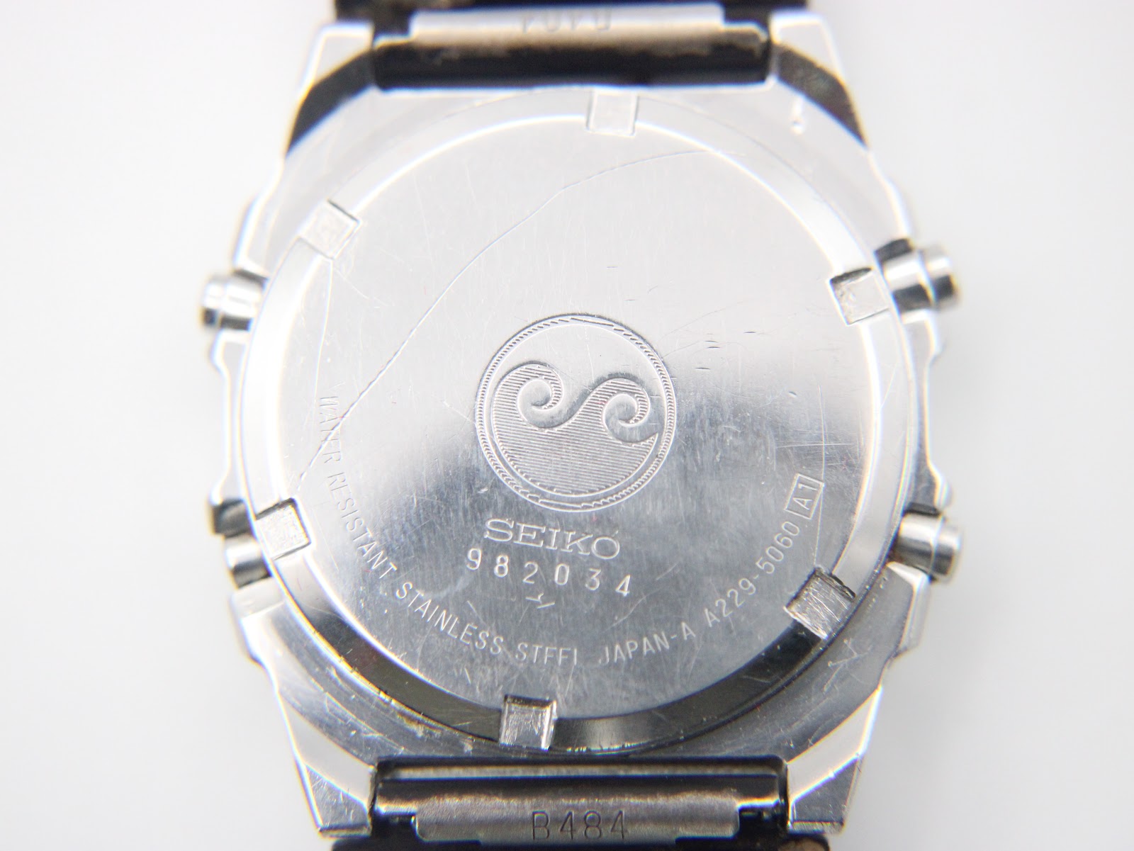 Close-up of the stainless steel case back of the Seiko A229-5060, revealing the serial number 982034 and "WATER RESISTANT" engraving.