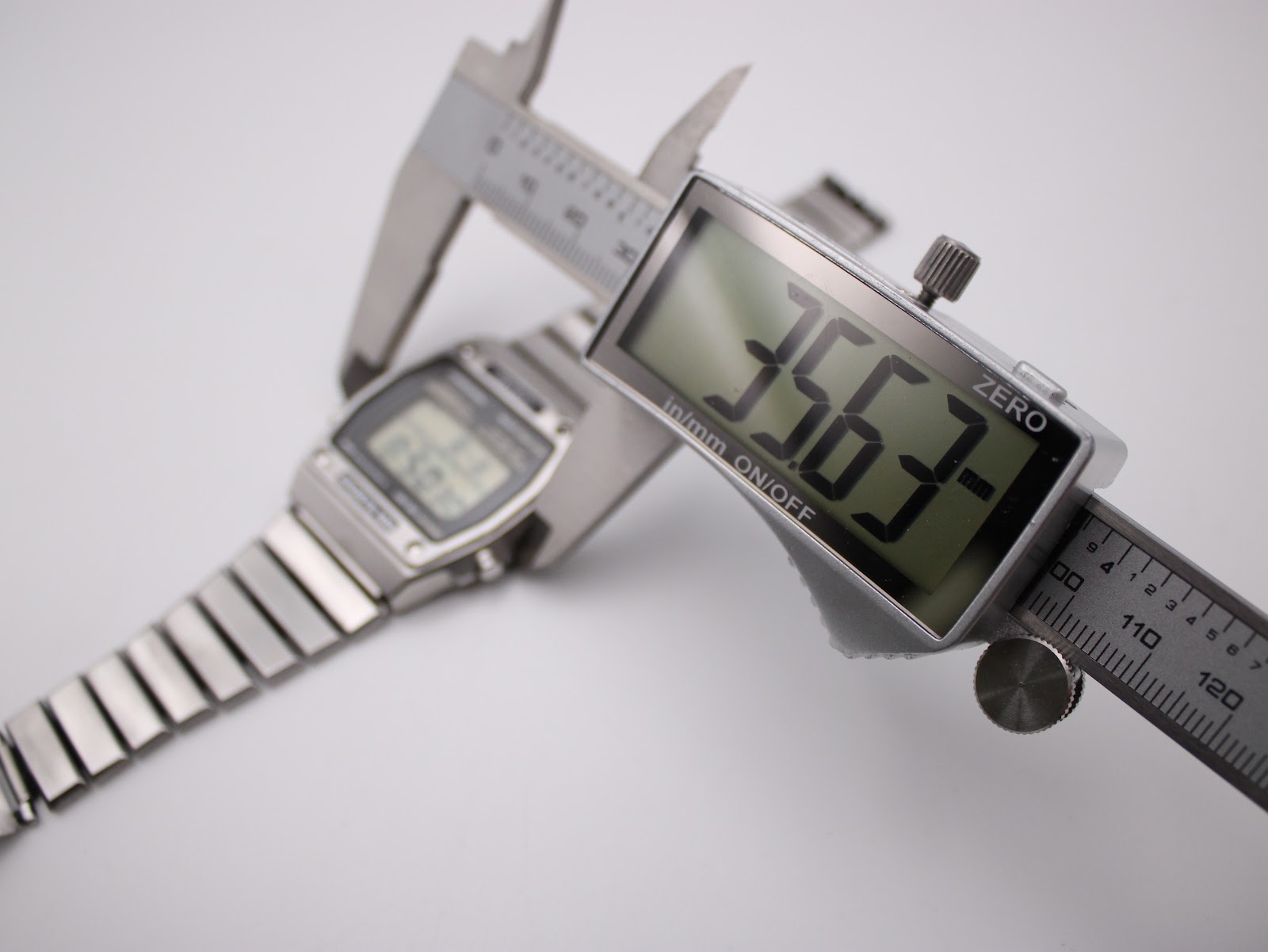 A digital caliper measuring the case diameter of the Seiko A229-5060, displaying a precise measurement of 35.63mm.