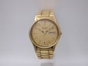 Front view of vintage Seiko 5H23-7B70 quartz watch with gold sunburst dial and day-date window.