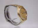 Opposite side view of the Seiko watch on a display stand, highlighting the integrated gold-tone bracelet.
