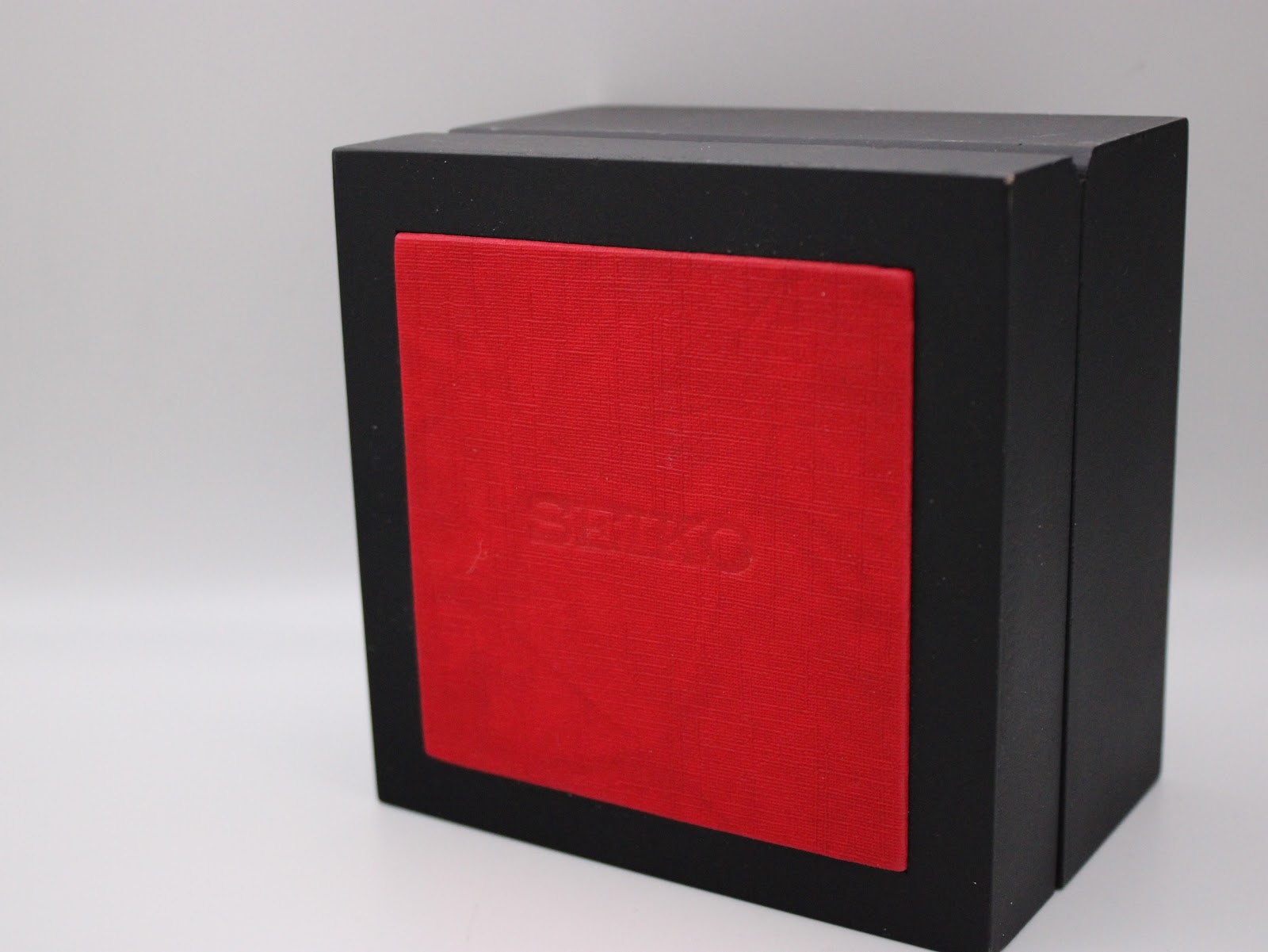 Closed black and red generic presentation box with "SEIKO" embossed on the red textured surface.