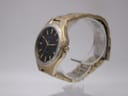 Angled side view of the Seiko watch, showing the gold tone case, crown, and integrated bracelet.