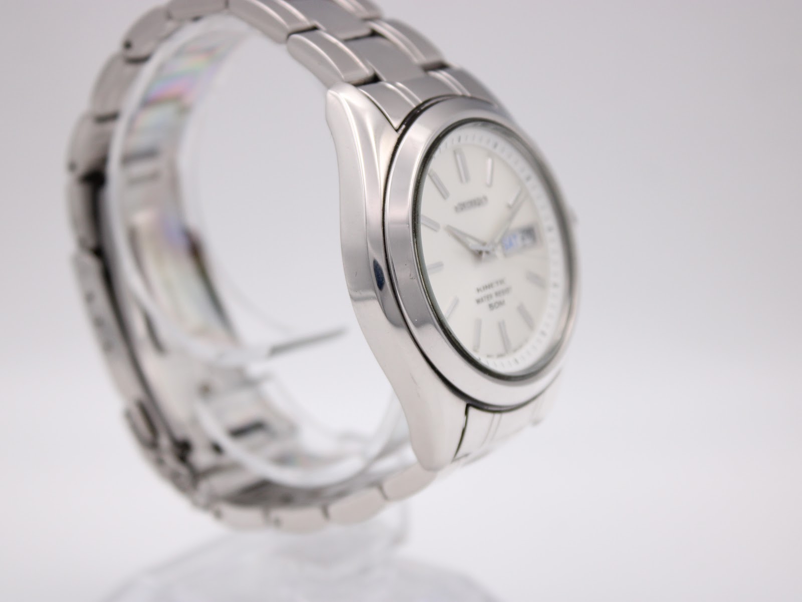 Angled side view of the Seiko Kinetic watch showing the stainless steel case and integrated bracelet on the left side.