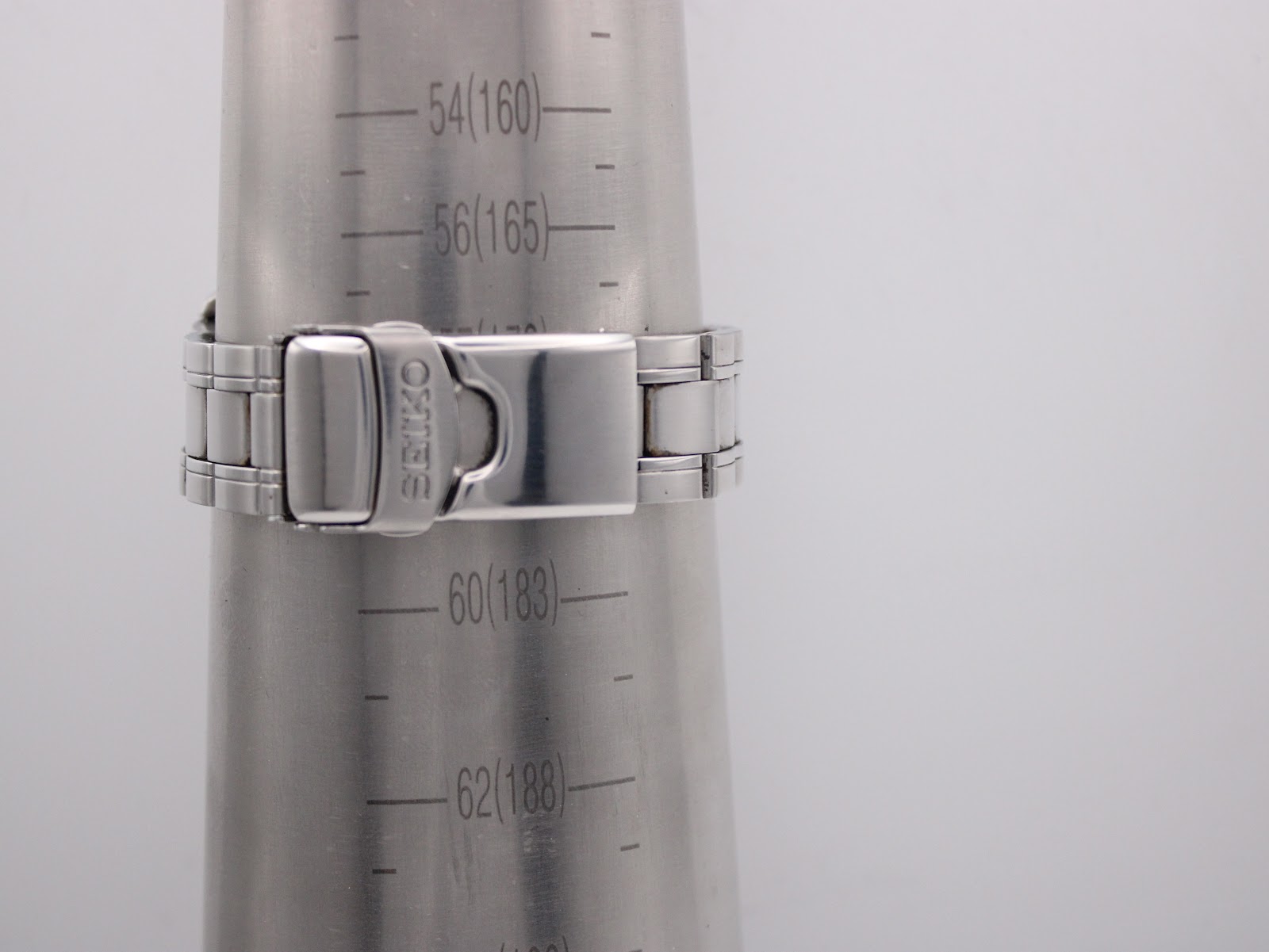 Close-up of the integrated stainless steel bracelet of the Seiko watch, clasped around a wrist sizing gauge, showing a wrist size of 178mm.