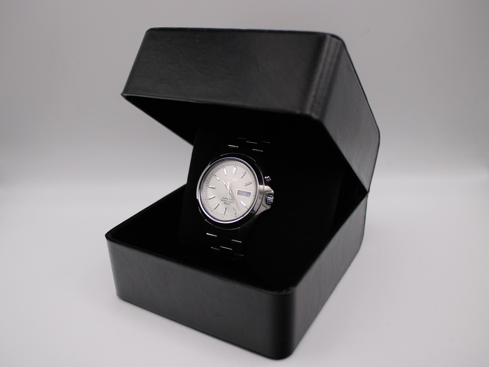The Seiko Kinetic watch presented within an open black display box, highlighting its overall appearance.