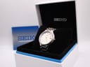 Front view of Seiko 7N42-8090 titanium quartz watch with white dial and gold baton indices.